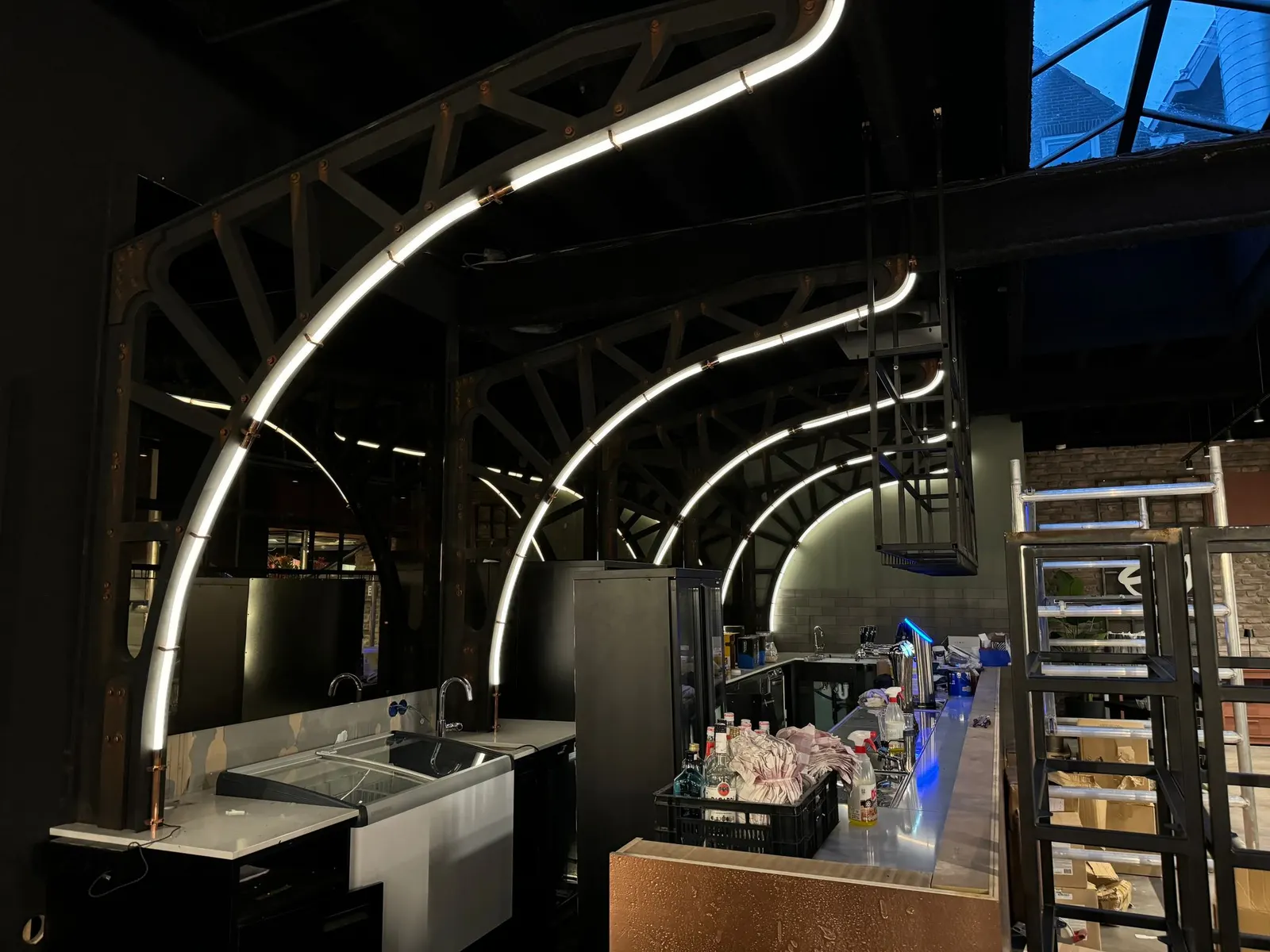 Gebogen lichtlijnen boven de bar van Restaurant Dadawan in Roermond